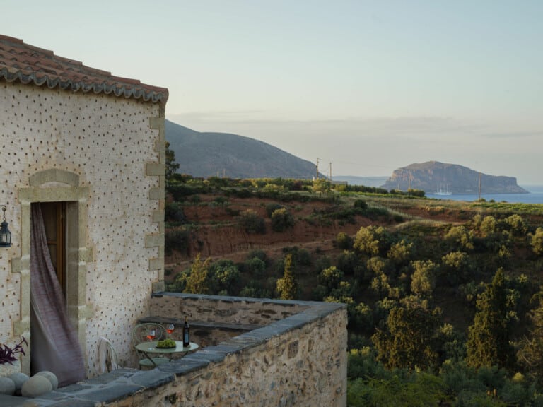Alt tag: The balcony of Kinsterna, an awarded Monemvasia boutique hotel, overlooking the vineyards of the estate and Monemvasia rock in the background.